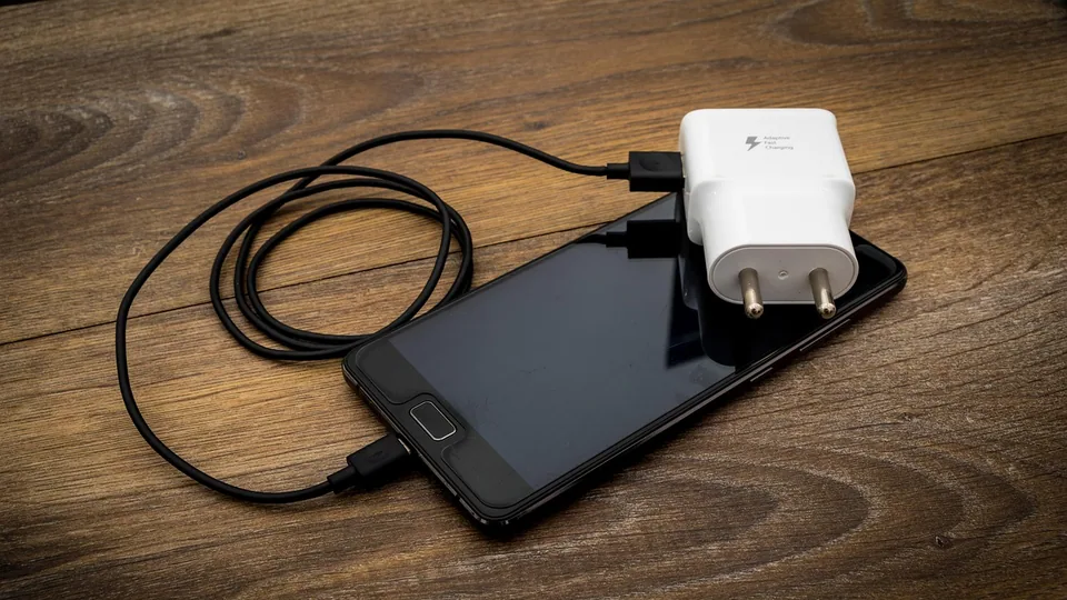 Laddkabel ansluten till en telefon på ett bord